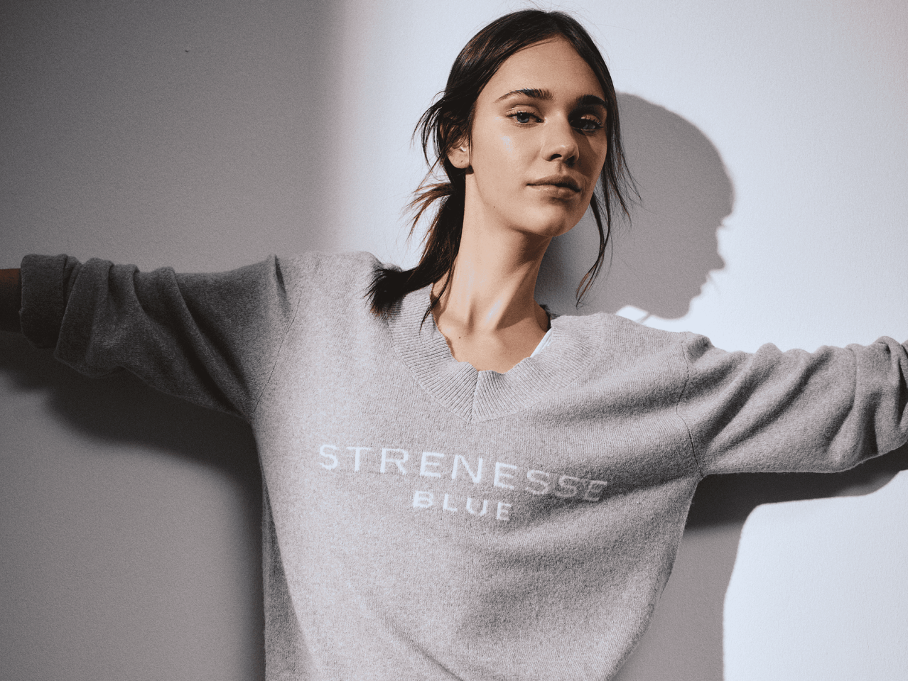 Frau in grauem Strickpullover mit 'STRENESSE BLUE' Aufschrift