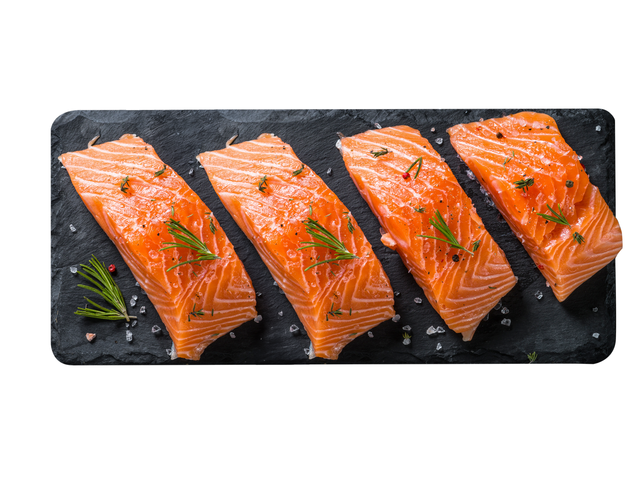 Keturios sūdytos lašišos filė gabalėliai ant juodo akmens lentos.