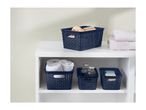 Navy blue woven plastic storage baskets organize bathroom essentials on a white shelf.