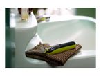 Philips OneBlade shaver on a brown towel next to a sink with a bottle of oil