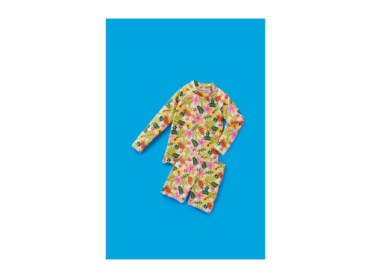 Kids' floral long-sleeve rash guard and matching shorts on a blue background.