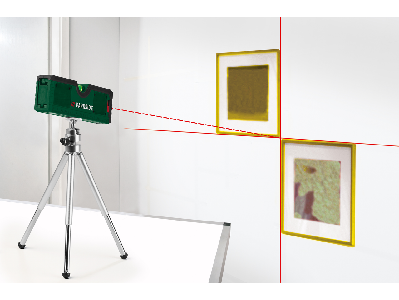 Nível a laser Parkside em tripé, projetando linhas vermelhas numa parede com dois quadros.