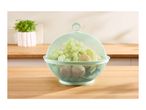 Light green mesh fruit bowl with lid, filled with grapes, kiwis, and oranges, on a wooden counter.