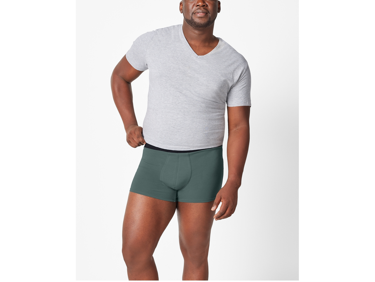 Bărbat cu tricou gri și boxeri verde închis.