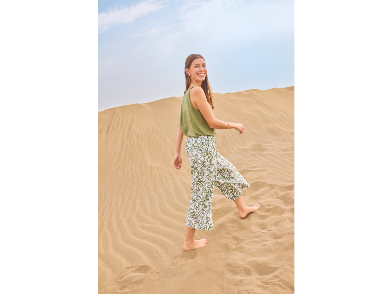 Calças culotte femininas ESMARA com estampa de folhas verdes e brancas, usadas num deserto.