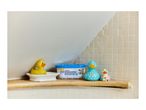 A compact dehumidifier on a bathroom shelf next to three rubber ducks.