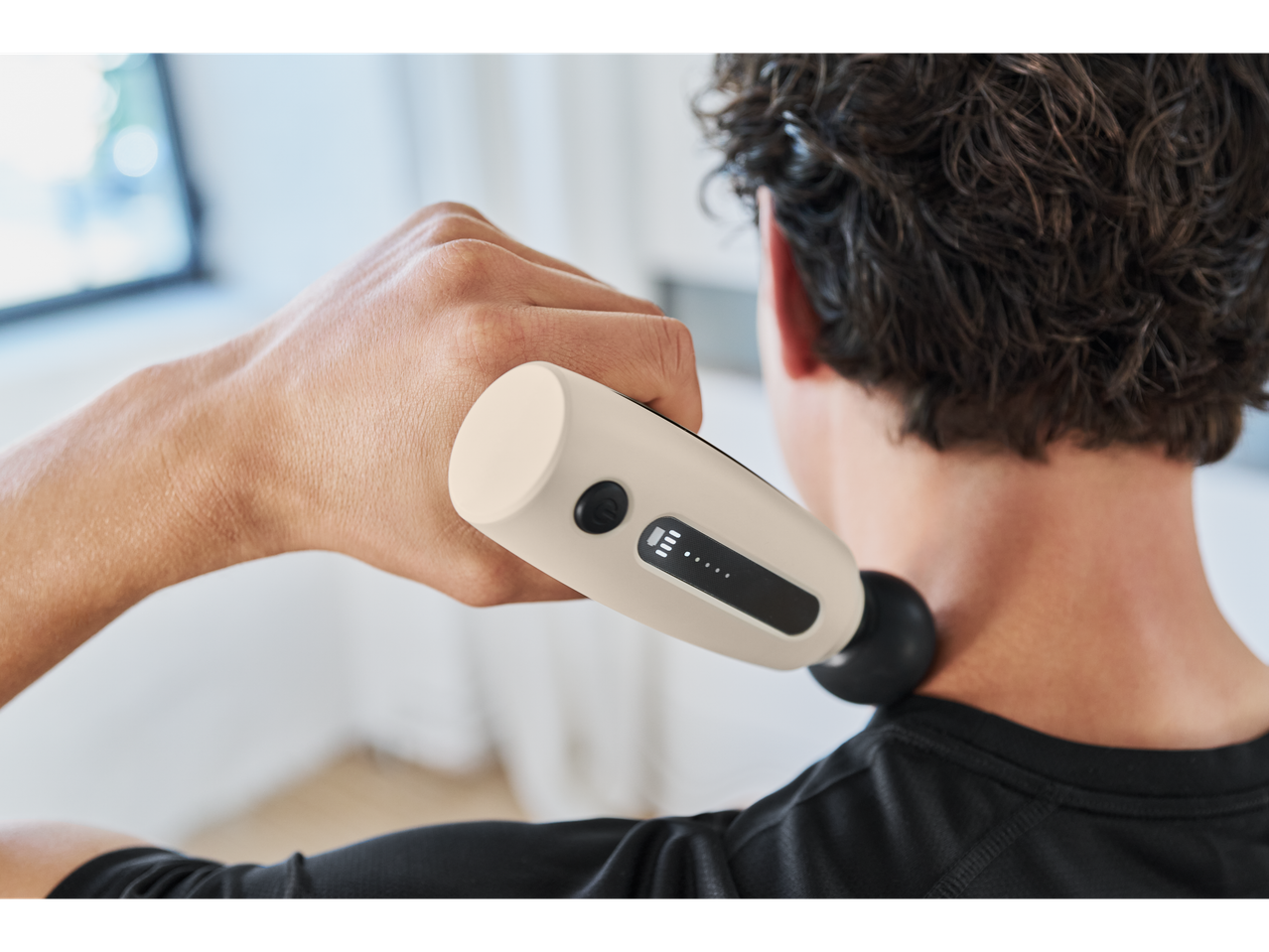 A person uses a CRIVIT Mini Massage Gun on their neck.