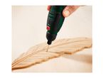 Hand engraving a feather shape into wood with a rotary tool.