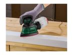 Hand wearing a glove operating a delta sander on a white wooden plank.