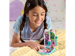A girl playing with a Gabby's Dollhouse Purrfect Playset on a fluffy blanket.