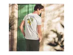 Man in white t-shirt with lemon print and 'La Dolce Vita' text, dark green trousers.