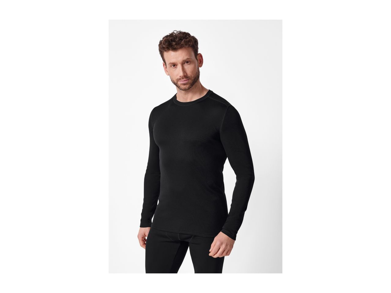 A man wearing a black long-sleeved thermal top and matching thermal pants.