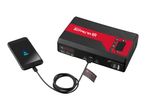 A black and red portable power bank charging a smartphone.