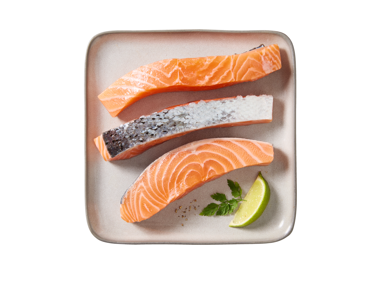 Kolm toorest lõhefileed taldrikul, kaunistatud laimiviilu ja peterselliga.