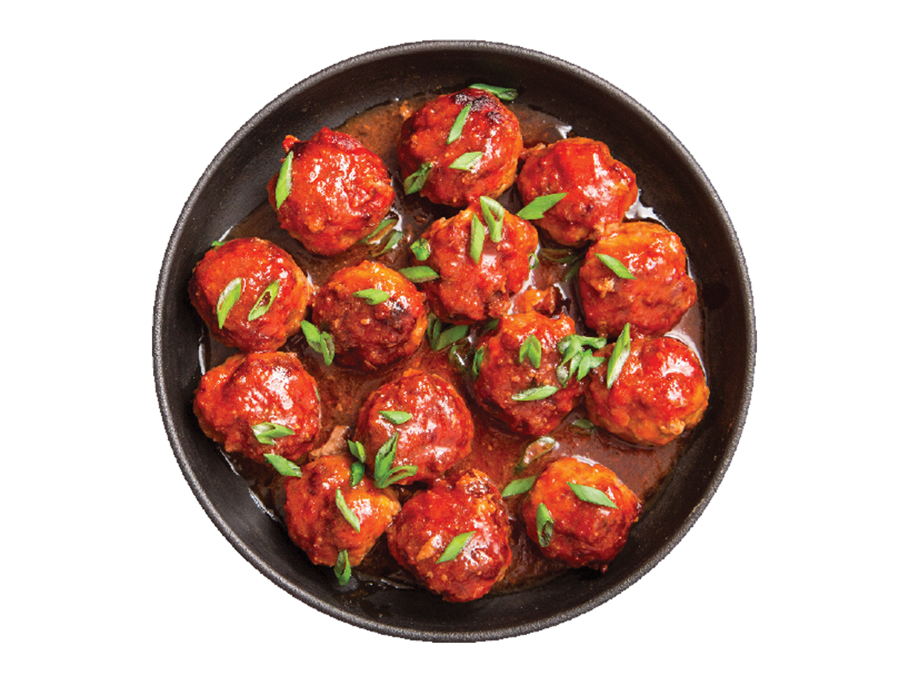 Gaļas bumbiņas ar sarkanu mērci un zaļumiem melnā pannā.