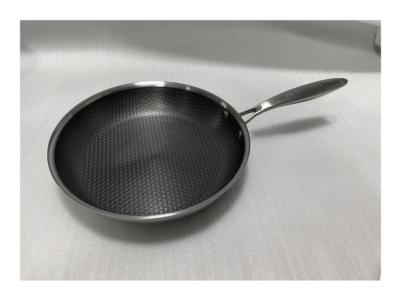 A stainless steel frying pan with a long handle.