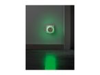 A night light plugged into a wall socket, casting a green glow on the wall and floor.