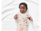 Baby in pink pajamas with koala and kangaroo print.