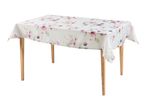 Table with a light floral tablecloth featuring pink and purple flowers and green leaves.
