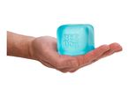 A hand holding a translucent blue ice cube with embossed letters.