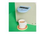 Toy coffee machine with a cup of coffee on a coaster.
