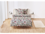A sage green duvet cover set with a pink floral print sits on a bed, styled with matching pillows and a small rug.