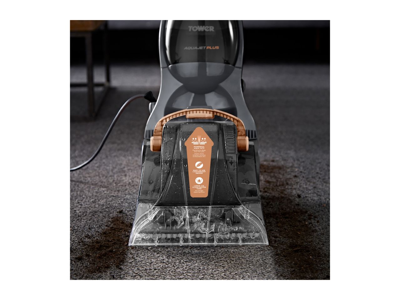 A Tower Aquajet Plus carpet cleaner is shown cleaning a dark carpet with dirt.