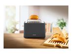 A SilverCrest toaster with a bun on top, next to a breadboard with rolls.