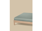 A light green fitted sheet on a wooden bed frame against a beige background.