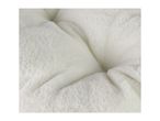 Close-up of soft, fluffy white faux fur fabric, possibly a pet bed or blanket.