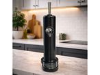 Black beverage dispenser on a marble kitchen counter with white subway tile backsplash.