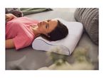 Woman sleeping on a white ergonomic pillow in bed, wearing a pink t-shirt.