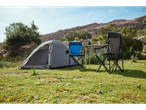 Uma barraca de camping cinza, duas cadeiras dobráveis e uma mesa dobrável em um cenário montanhoso.