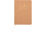 Ένα μπεζ ημερολόγιο bullet journal από δέρμα με χρυσές επιγραφές.