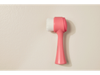 Uma escova de limpeza facial rosa com três tipos diferentes de cerdas.