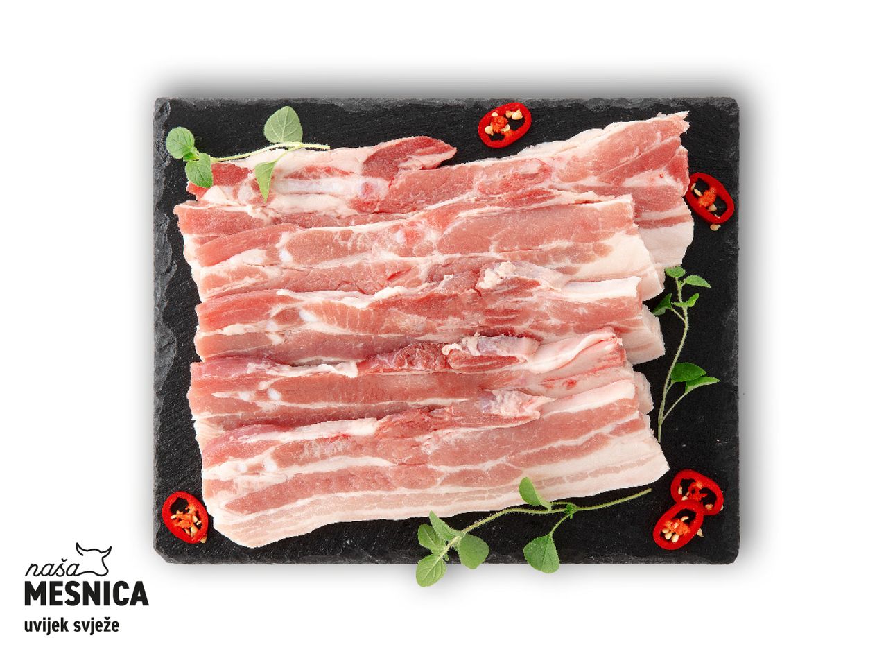 Slanina na crnoj ploči, začinjena s crvenom paprikom i bosiljkom. Naša Mesnica - uvijek svježe.