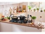 Cozinha com panelas Silvercrest® no fogão, preparando massa e vegetais.