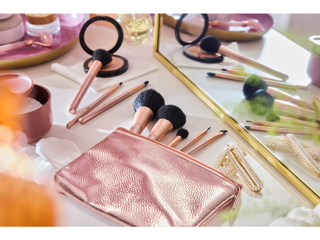 Bolsa de maquiagem rosa com pincéis de maquiagem CIEN BEAUTY e acessórios em uma penteadeira.