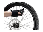 Hand in cycling glove checking bicycle tire pressure with a digital gauge.