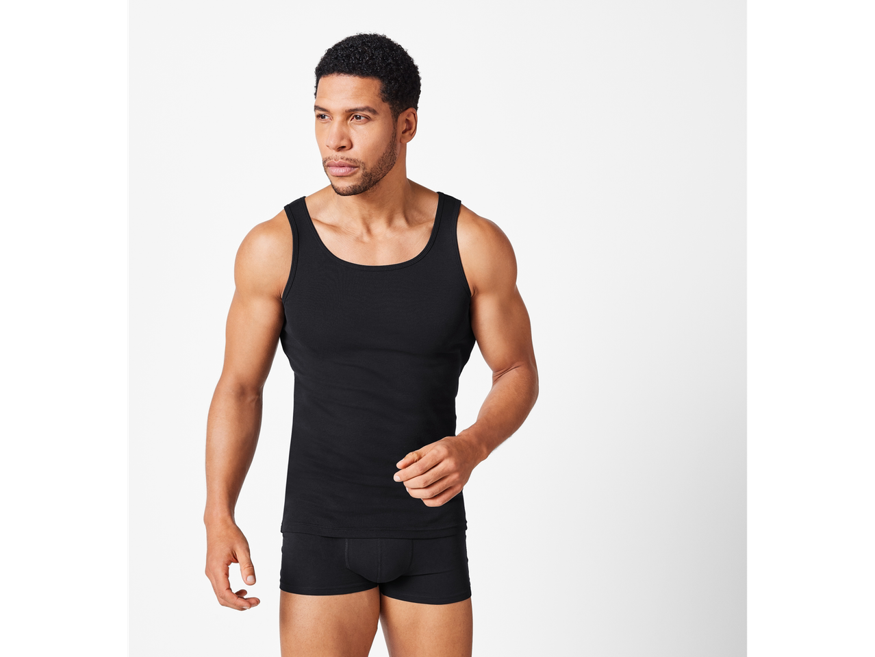 Bărbat îmbrăcat într-un maiou și boxeri negri.