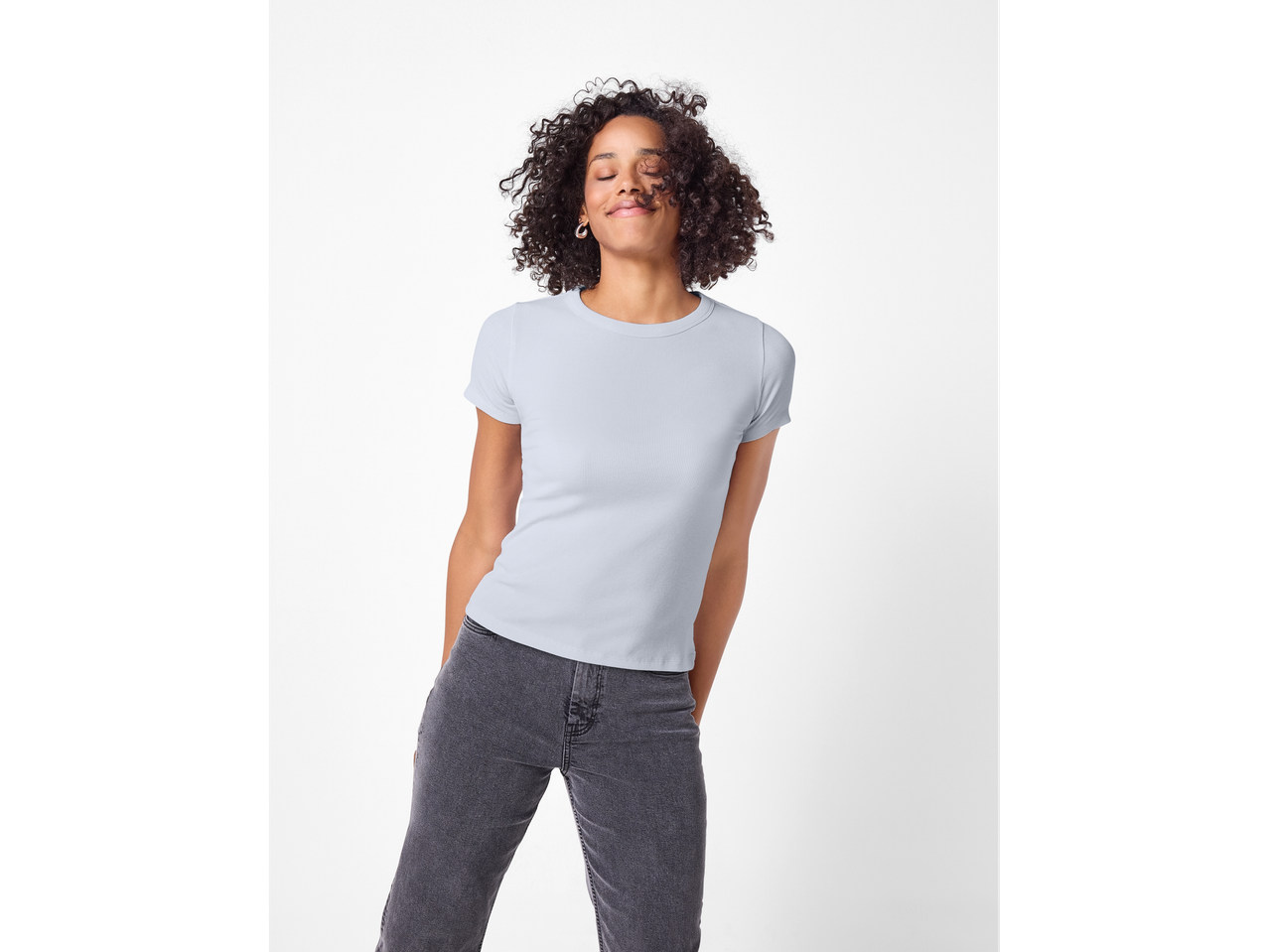 Žena nosi Esmara® rebrastu majicu i sive traperice