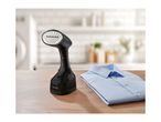 Handheld garment steamer and a folded blue shirt on a wooden table.