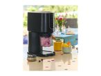 Ice cream maker with blueberry and mango desserts on a table with confetti.