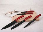 A set of Berlinger Haus kitchen knives with red handles and black blades on a wooden cutting board.