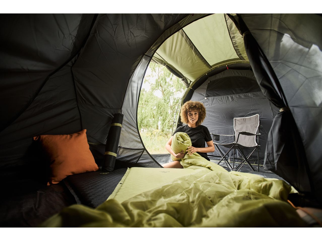 A person relaxes inside a camping tent.