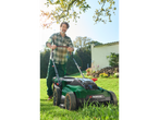 Man using a Parkside lawnmower in a garden.