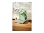 Mint green espresso machine with a pressure gauge, portafilter with ground coffee, and coffee beans.
