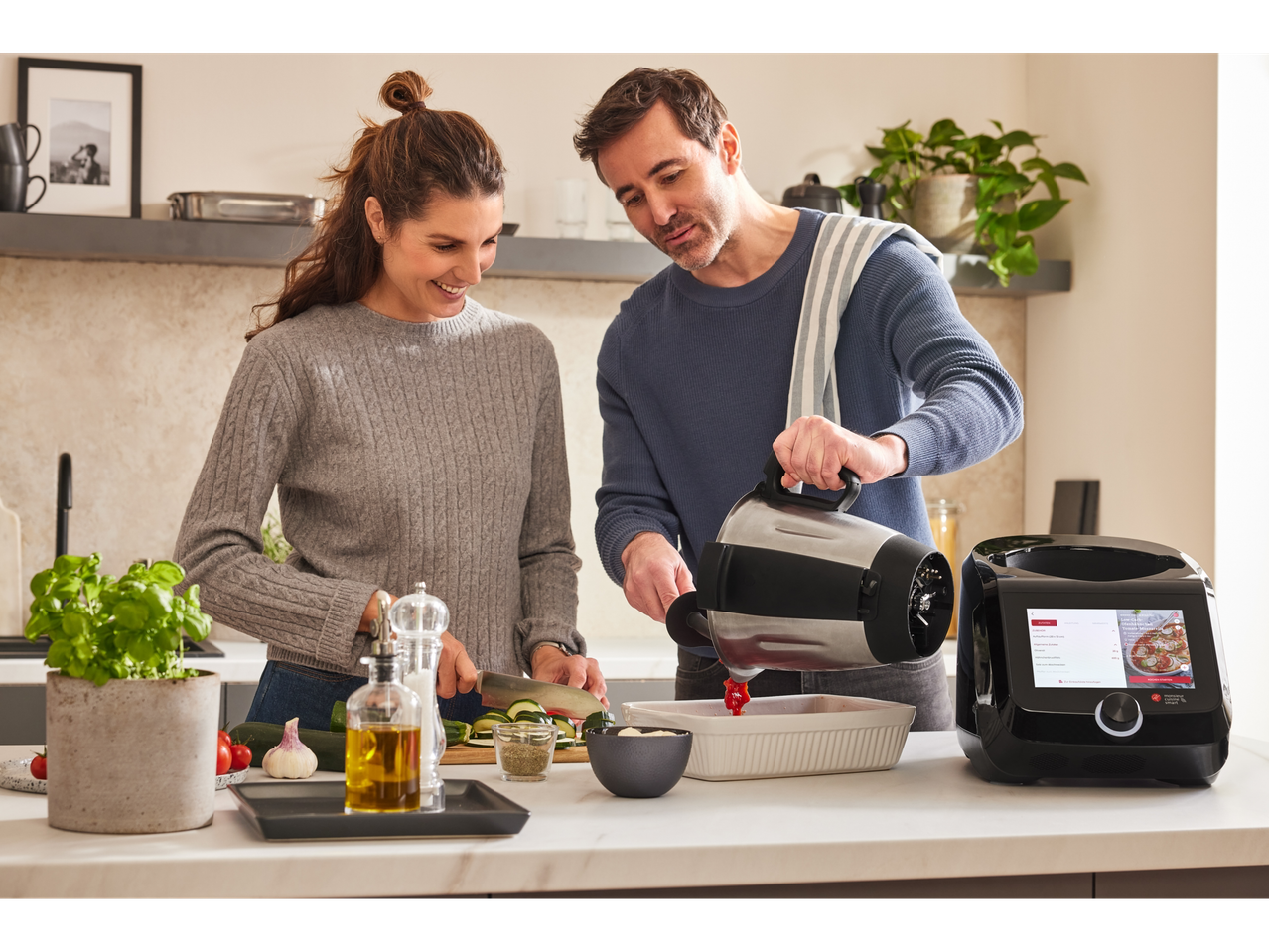 Cuplu gătește cu Monsieur Cuisine Connect: robot de bucătărie și blender.