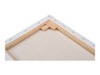 Back view of a stretched canvas with wooden frame and staples, showing the texture of the canvas.
