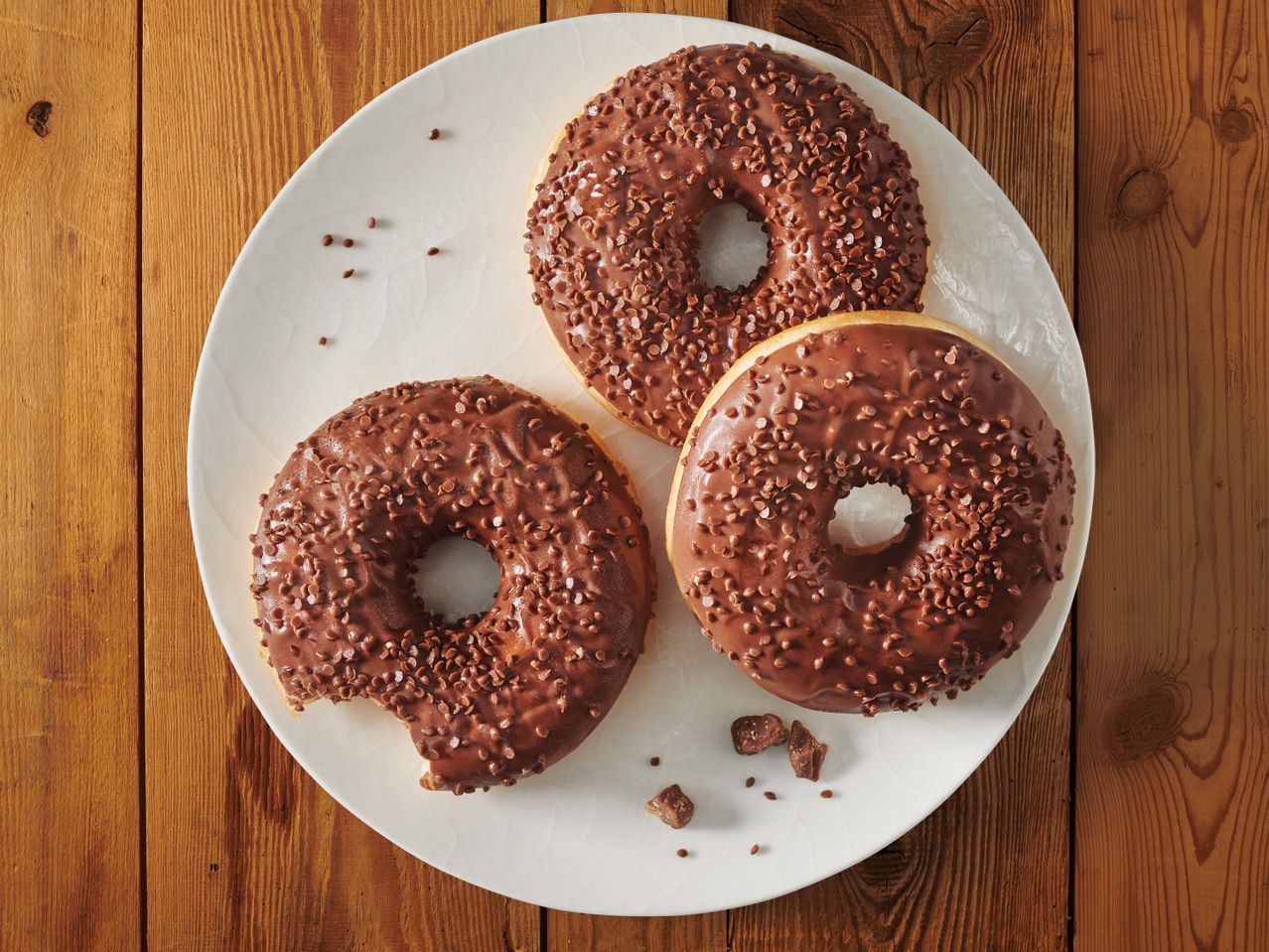 Шоколадови понички с шоколадови пръски на дървена маса.